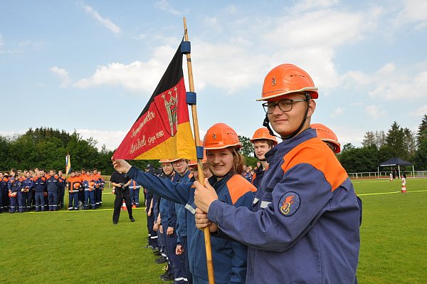 Marvin Timmermann (von rechts) und Celine Fehr -mit der Fahne der Jugendfeuerwehr Brakel zählen zu den knapp 300 Jugendlichen, die um die begehrte Leistungsspange wetteiferten. - © Helga Krooß