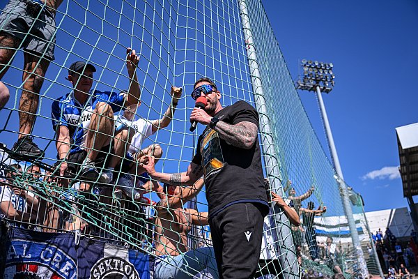 Arminia-Trainer Mitch Kniat kam der Aufforderung der Fans nach und machte auf dem Zaun den Vorsänger. - © Teresa Kroeger/RHR-FOTO