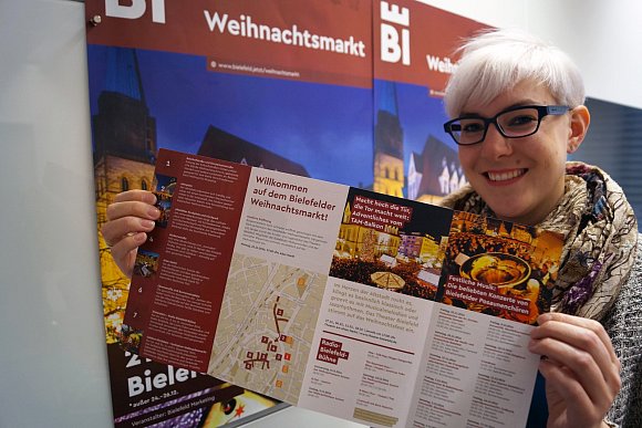 Katharina Schilberg, Projektleiterin bei Bielefeld Marketing, zeigt den aktuellen Programm-Flyer im neuen Design der Stadtmarke Bielefeld. - © Bielefeld Marketing GmbH