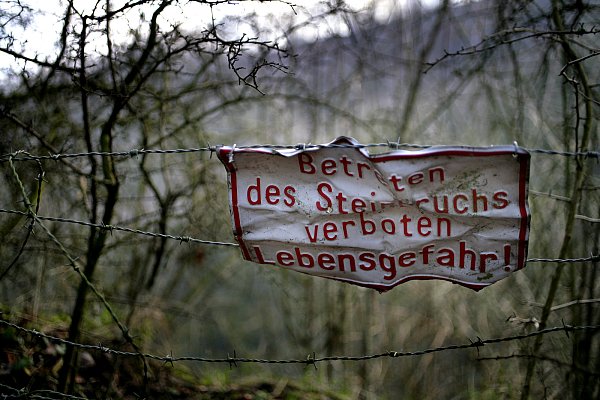 Ein Schild oberhalb der Felskante des Oberlübber Bergsees warnt vor den Gefahren des nahezu senkrecht abfallenden Geländes. Der Hauptangeklagte Jörg Z. sprach in der Untersuchungshaft über das Gewässer, wo er den Jeep Meyers angeblich verschwinden ließ. Die Beschreibung passt auch auf den Bergsee. - © Fotos: Tyler Larkin