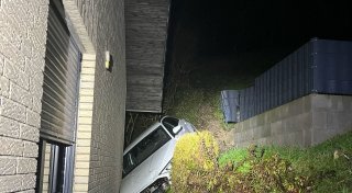 Auto klemmt zwischen Haus und Abhang