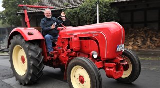Porsche-Trecker in Ferrari-Rot fährt im Warburger Oktoberwochen-Festumzug mit