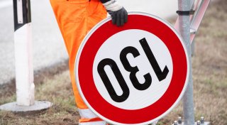 Geschäftsmann rast mit Handy in der Hand bei 260 über die Autobahn