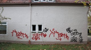 Autos und Hauswand in Bad Lippspringe mit Farbe besprüht