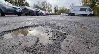 Besucher moniert Schlaglöcher auf dem Parkplatz an der Bünder Welle