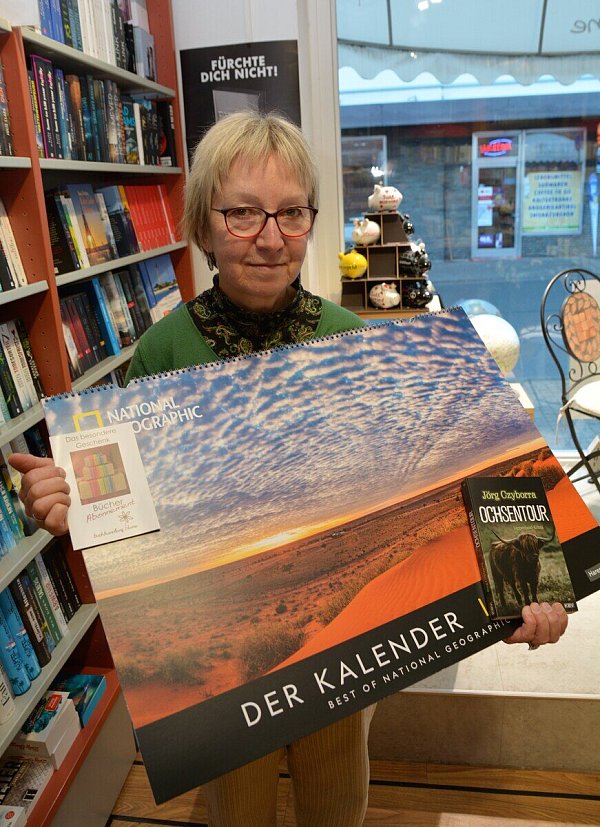 Einen Kalender für das Jahr 2023 hat Martina Lange von der Buchhandlung Blume herausgesucht, außerde, das Buch "Ochsentour" mit lokalem Bezug und ein Bücher-Abonnement. - © Karin Prignitz