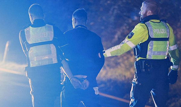 Polizisten nehmen den Lastwagenfahrer (M) in Gewahrsam. - © Alex Talash/dpa