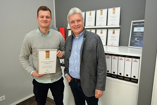 Julian und Rüdiger Kriemelmann mit der mittlerweile elften Urkunde, die dem Maklern bescheinigt, zu den 1.000 Besten in ganz Deutschland zu gehören. - © Karin Prignitz