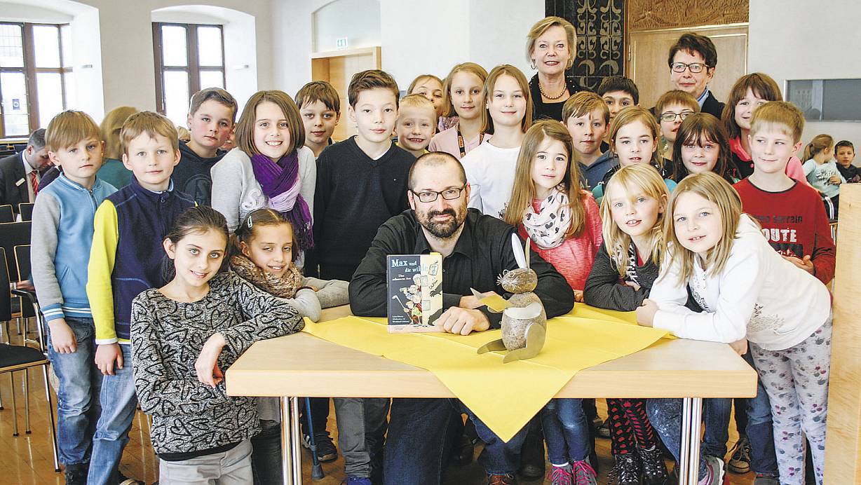 Preisverleihung: Autor Winfried Oelsner gewann für sein Buch "Max und die wilde 7"den "Paderborner Hasen". Direkt eben ihm stehen die Gewinner des Vorlesewettberwerbs, Jonas Hütte und Leni Schuster, mit ihren Mitschülern. Organisatorin Ulrike Mertens und Katharina Linnemann (hinten v.l.) freuen sich mit dem Autoren. | © Birger Berbüsse