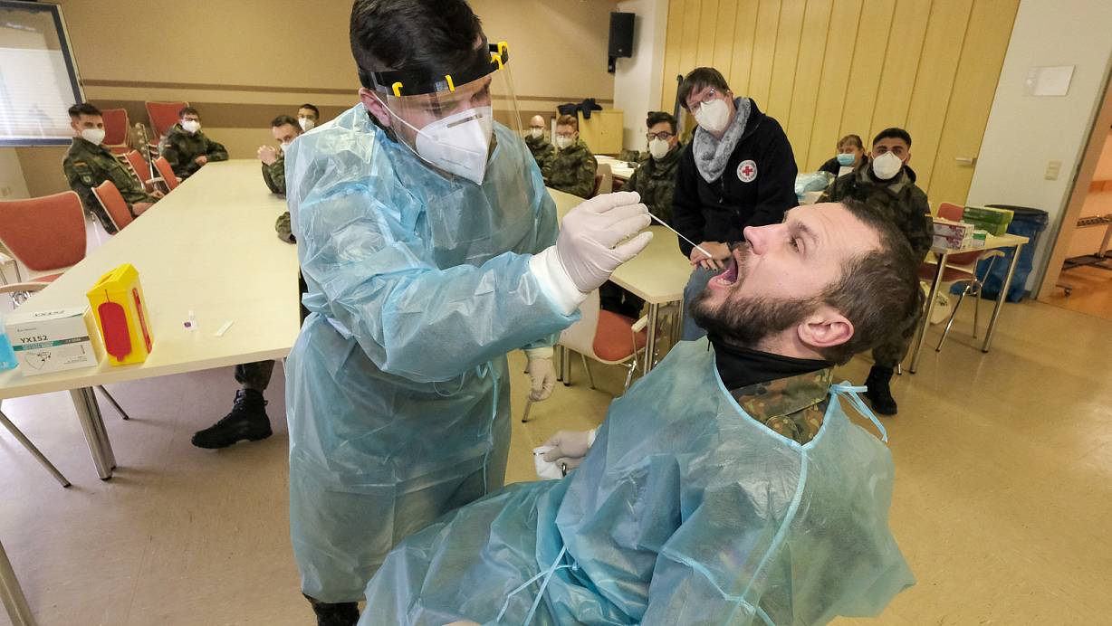 Der Gefreite Roman Spanberger (l.) übt den korrekten Rachenabstrich beim Oberstabsgefreiten Oleg Mast. Petra Dommasch vom DRK und die übrigen Soldaten schauen genau hin, ob das Stäbchen korrekt geführt wird. | © Foto: Andreas Zobe/NW