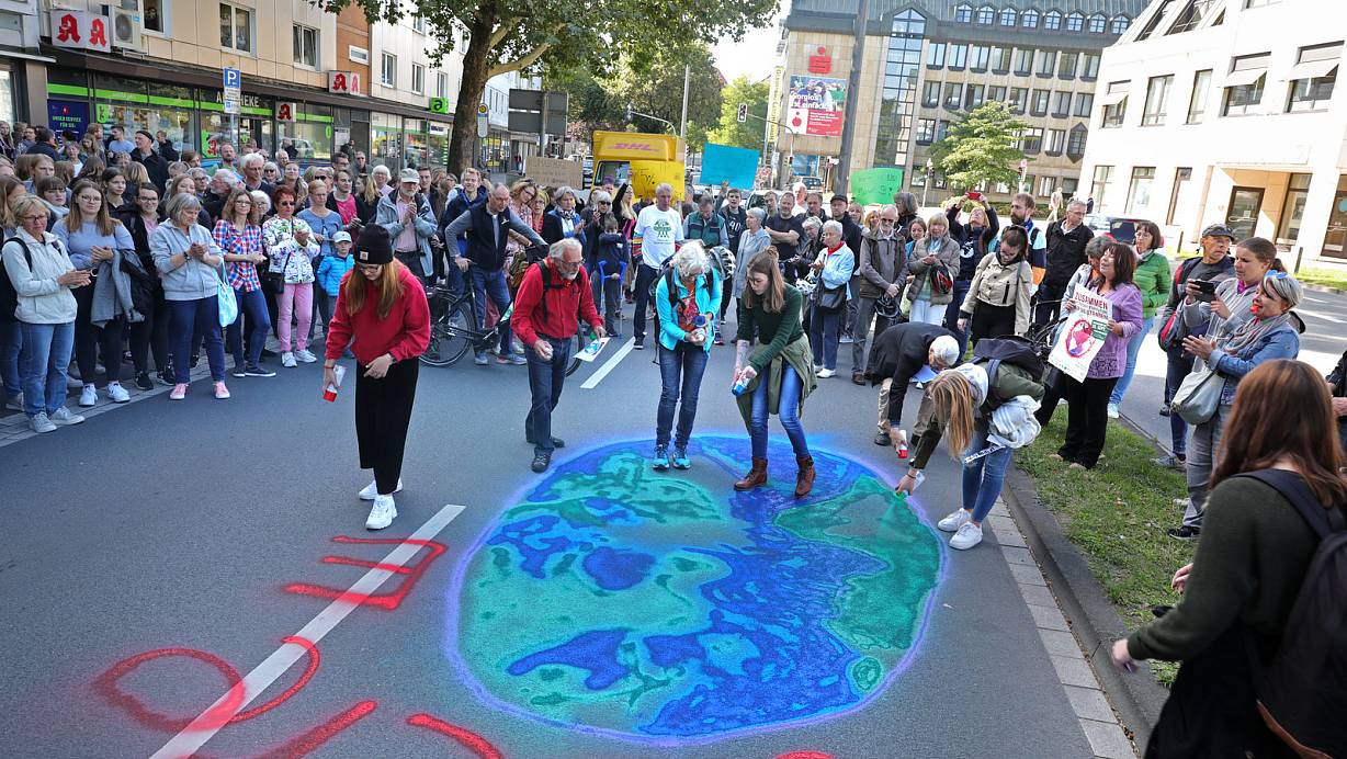 Die Erde retten: Mit einem vergänglichen Bild aus Kreide auf der Berliner Straße setzten die Demonstranten ein Zeichen. Die Botschaft: "Wollen wir die Erde totfahren?" | © Frank-Michael Kiel-Steinkamp