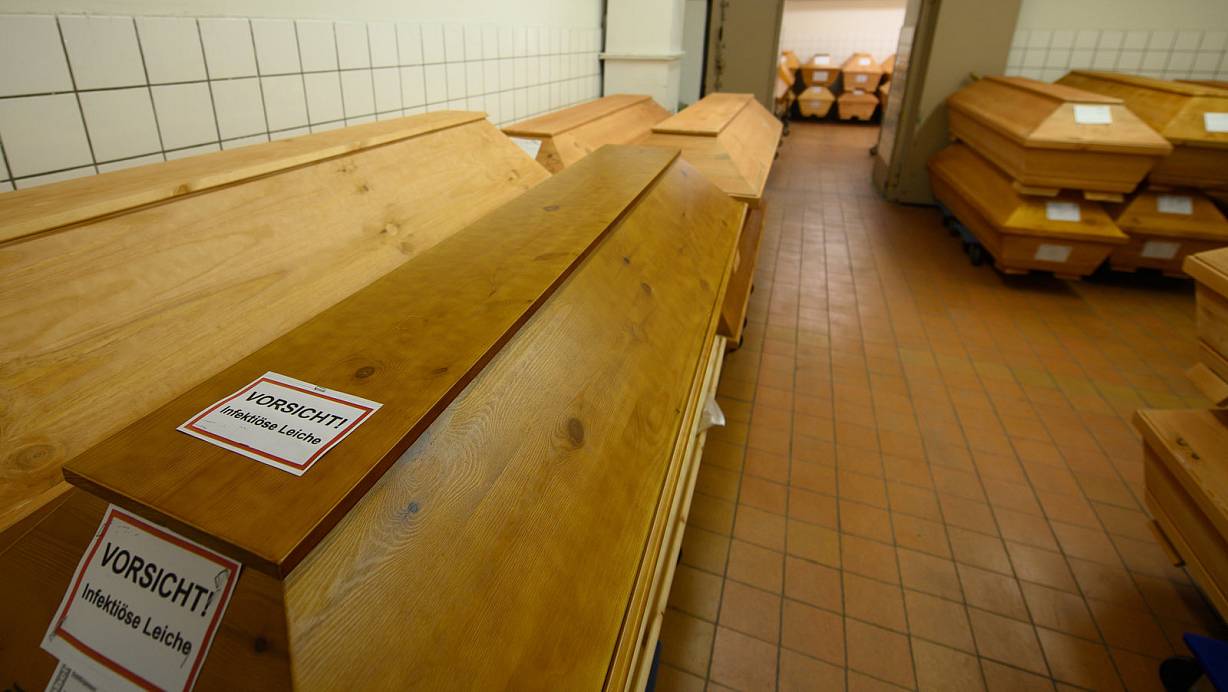 "Vorsicht infektiöse Leiche" steht auf einem Sarg mit einem Verstorbenen, der an oder mit dem Coronavirus gestorben ist. | © Robert Michael
