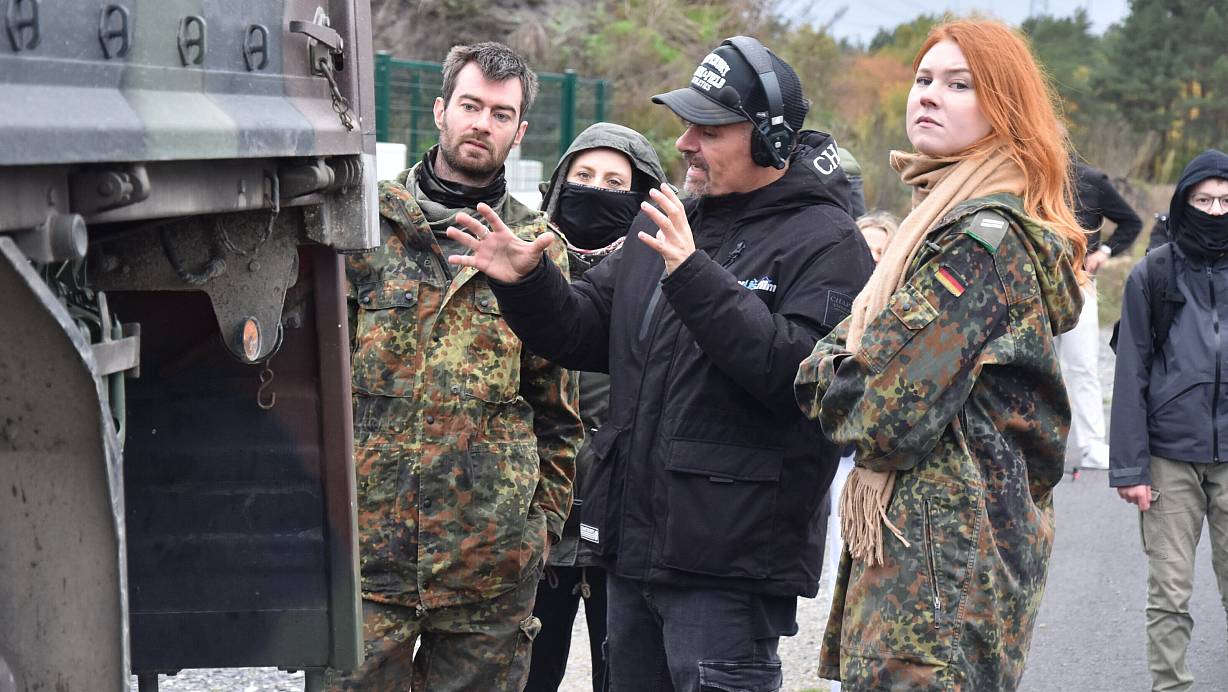 Regisseur Matthias Kampmann gibt den Komparsen bei den Dreharbeiten im Kreis Gütersloh letzte Anweisungen. | © Sigurd Gringel