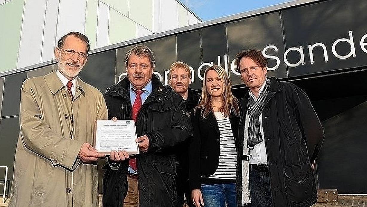Dr. Bernd Steinmüller übergibt Volker Hermann, Betriebsleiter des Gebäudemanagements der Stadt Paderborn, in Anwesenheit von Tobias Zenke, GMP, sowie Sonja Werge und Uwe Balhorn vom Architekturbüro aws das Passivhaus-Zertifikat. | © FOTO: STADT-PRESSEAMT