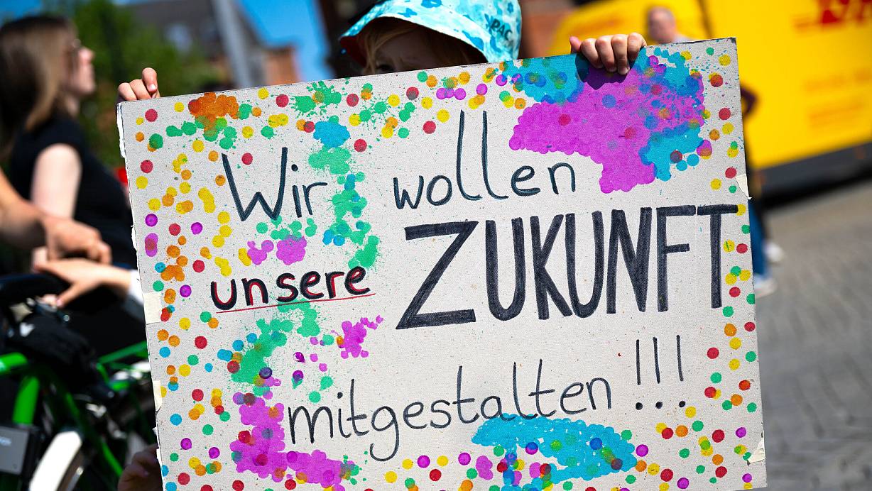 Ein Jugendlicher hält bei einer Demonstration ein Plakat mit der Aufschrift "Wir wollen unsere Zukunft mitgestalten!" | © picture alliance/dpa