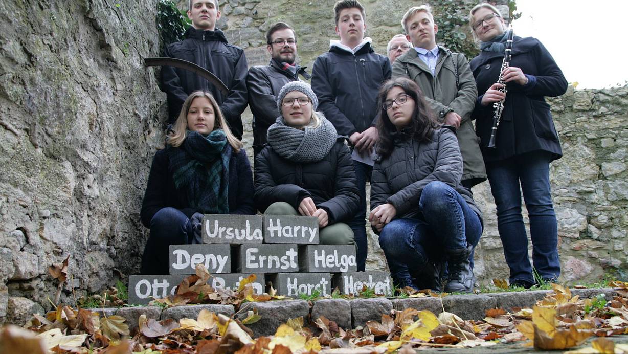 Erinnern: Emma, Sonja und Madeline knien vor den Denksteinen am Jüdische Friedhof. Gemeinsam mit ihren Mitschülern haben sie an die Novemberpogrome 1938 erinnert. | © Angelina Kuhlmann