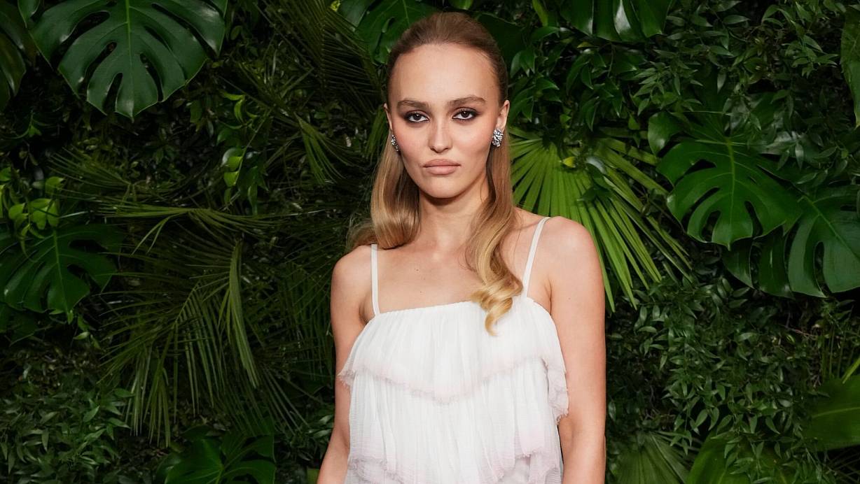 Schauspielerin Lily-Rose Depp schaut in typischer roter Teppich-Pose mit kühler Miene in die Kamera. (Archivbild) | © Jordan Strauss/Invision via AP/dpa