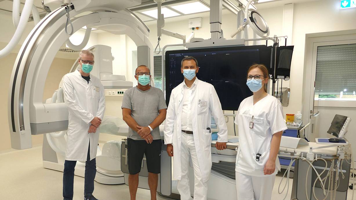 Der Chefarzt der Klinik für Neurologie in Paderborn, Thomas Postert (v. l.), Patient Michael Holz, Chefarzt Mete Dadak und die medizinisch-technische Radiologie-Assistentin Monique Lerch vor der neuen Röntgenanlage. | © St.-Vincenz-Krankenhaus