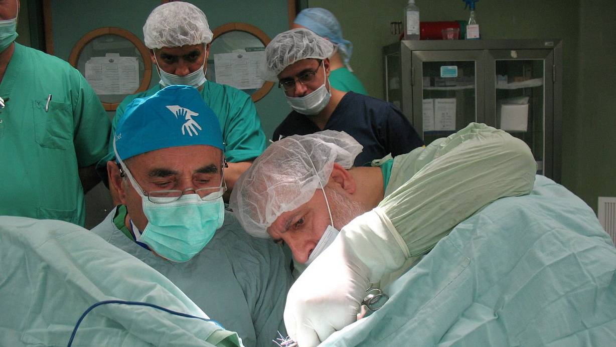 Bei der Arbeit: Dr. Emma (mit Brille) und der Chefarzt des „Shifa“-Hospitals legen gemeinsam Hand an. Auf der OP-Haube von Dr. Emma: das Logo des „Palestine Children’s Relief Fund“ . Foto: HFO | © Meiko Haselhorst