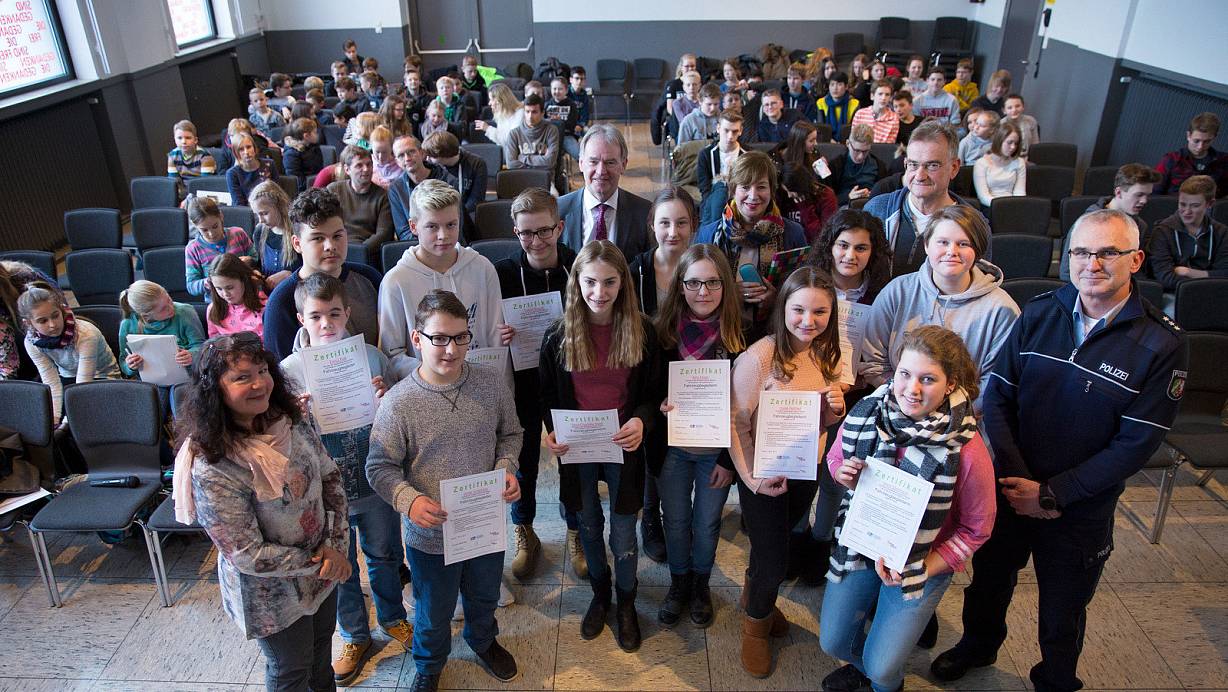 Würdigung: Christina Pörtner aus dem "Up to you"-Team (v.l.) gab den Busbegleitern mit Bürgermeister Wolfgang Koch, Schulleiterin Karin Stallmann, Lehrer Wilhelm Bulla sowie Hauptkommissar Dietmar Hesse in der Aula des Gymnasiums am Markt am Freitag das Zertifikat mit dem Busbegleiterausweis. | © Noah Wedel