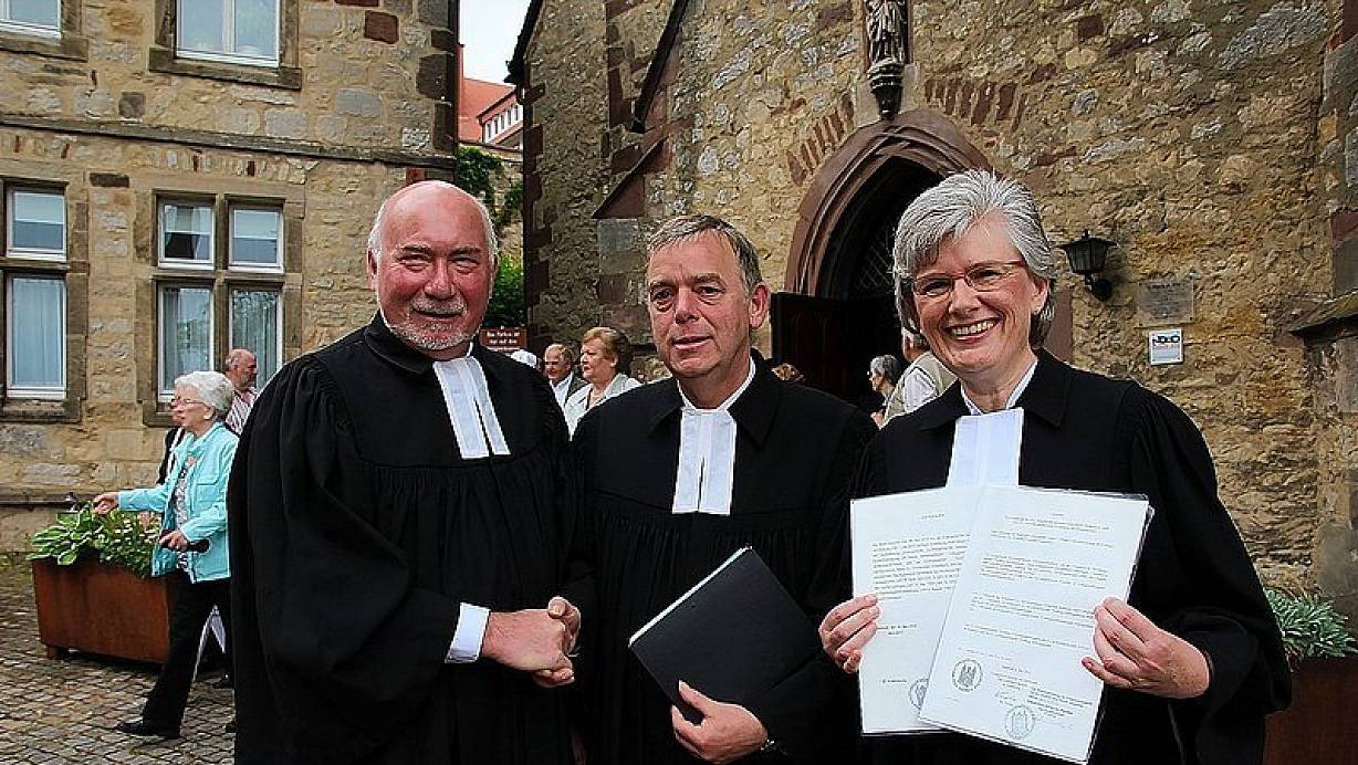 Pfarrer Karl-Heinz Bartsch und Pfarrer Karl Ludwig Wendorff (oben, v. l.) reichen sich die Hand. Superintendentin Anke Schröder zeigt die beiden Urkunden, die die Vereinigung der Warburger evangelischen Kirchengemeinden besiegeln. Nach dem Gottesdienst trafen sich die Bevollmächtigten (Foto, r.) mit ihren Gästen bei einem Empfang im Corvinushaus. | © FOTOS: DIETER SCHOLZ