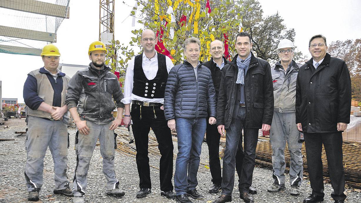 Vor dem Richtkranz: Andreas Lang (v. l.) und Andreas Folz, beide Maurer, Andreas Rohde, Holzbau Rohde, Architekt Rainer Krekeler, Johannes Brune, Technischer Leiter der KHWE, Bürgermeister Carsten Torke, Polier Jean Pierre Schiepers und KHWE-Geschäftsführer Reinhard Spieß. | © KHWE