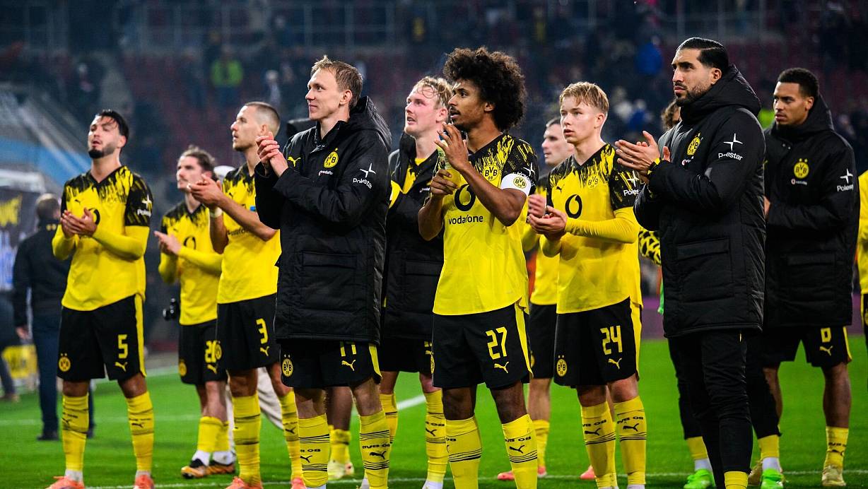 Hauptsache gewonnen: Dortmunds Spieler nach dem 1:0 in Augsburg vor ihren mitgereisten Fans. | © Tom Weller/dpa
