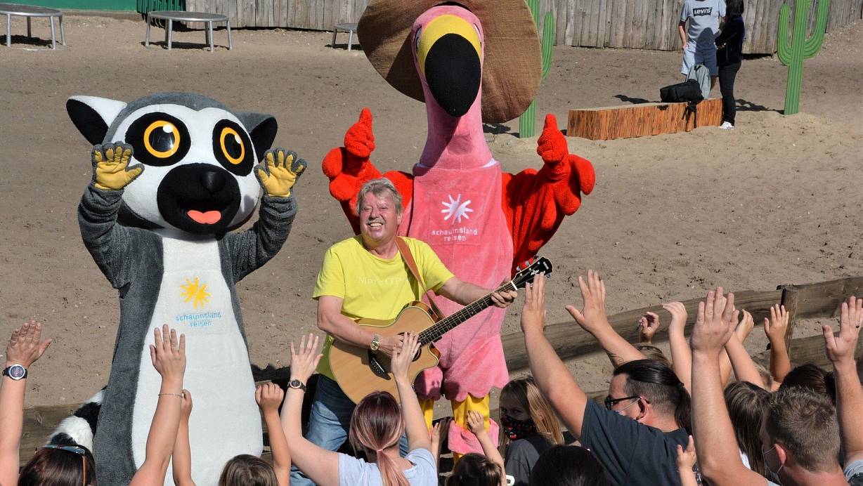 Volker Rosin ist am Weltkindertag in das Safariland gekommen. In der Westernstadt wird er von seinen Fans und von den beiden Maskottchen Katta und Ingo Flamingo begrüßt. | © Karin Prignitz