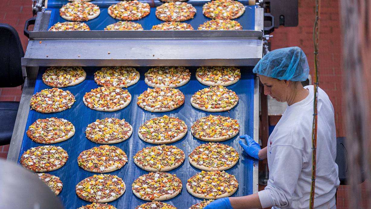 Pizzen werden in einem Werk von Dr. Oetker in Wittenburg produziert. Oetker sagt selbst, den Salzgehalt seiner Pizzen seit Jahren nach und nach zu senken. | © picture alliance / Jens Büttner/dpa-Zentralbild/ZB