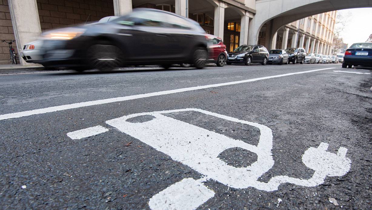 Freie Fahrt und kostenloses Parken? Ein Symbol eines Elektroautos markiert einen Parkplatz neben einer E-Ladesäule.  | © Julian Stratenschulte/dpa