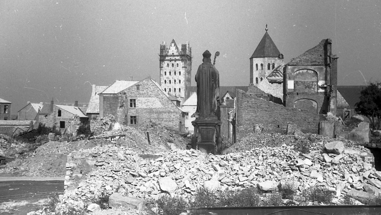 Blick über eine Steinwüste: Die Statue des Bischofs Liborius am Kamp überdauerte die Angriffe. Das Foto zeigt schon erste geflickte Dächer im Sommer 1945. Im Hintergrund der Domturm und der Turm der Gaukirche. | © FOTOS: STADTARCHIV PADERBORN