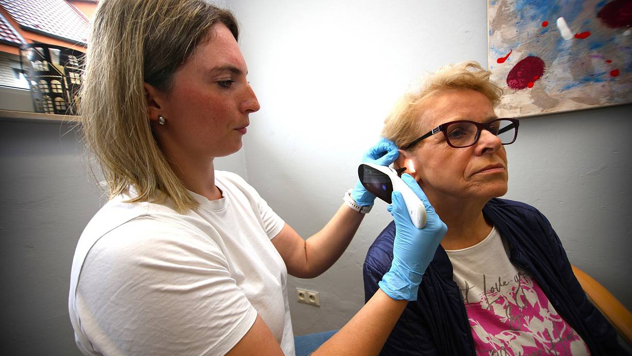 In der neuen Praxis in Etteln untersucht Assistentin Lea Kulp (l.) das Ohr von Patientin Adele Tietz mit einem Gerät zur Vordiagnose. | © Rajkumar Mukherjee