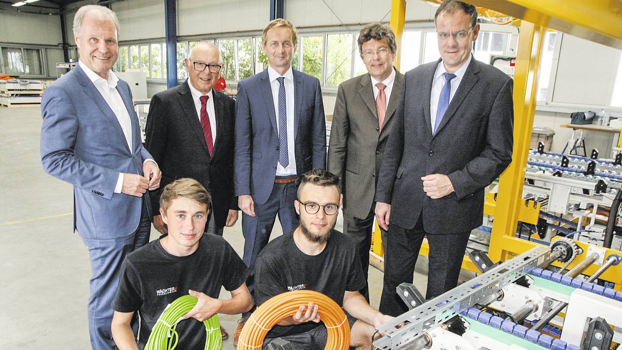 Besuch aus Bielefeld: (v. l.) IHK-Hauptgeschäftsführer Thomas Niehoff, Seniorchef Ferdinand Wächter (Wächter Packautomatik), Juniorchef Stefan Wächter, der kaufmännische Leiter Stefan Garfs und IHK-Geschäftsführer Swen Binner schauen Mechatroniker-Azubi Lukas Bermeier (Wewelsburg) und Industriemechaniker-Azubi Linus Baumann (Fürstenberg) über die Schulter. | © Andreas Götte