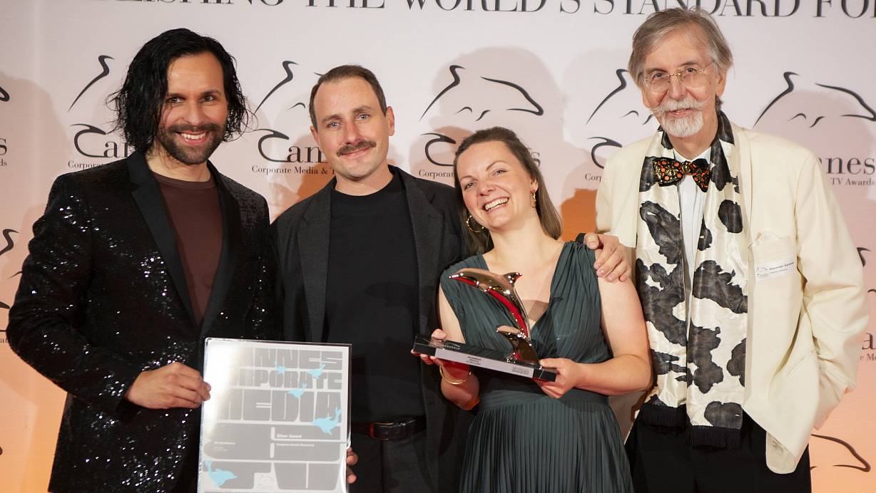 Delfin in den Händen – Lachen in den Gesichtern: Max Rahn (v. l.), Tobias Focke und Sonja Rössl von der Kreativagentur Lim aus Herford feiern den mit dem Silbernen Delfin preisgekrönten Denios-Film. Überreicht durch Festivaldirektor Alexander V. Kammel. | © Filmservice/Denios SE