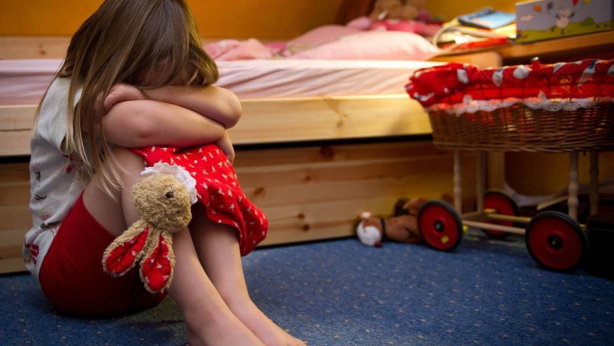 Ein kleines Mädchen sitzt weinend auf dem Fußboden in ihrem Zimmer. Viele Kinder benötigen ein Auslöser, um über die Taten zu sprechen. Die Kindersprechstunde soll das bieten. | © Symbolfoto: picture alliance / dpa
