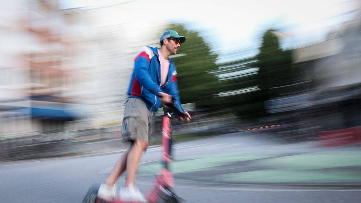 Ein Mann in Hamburg ist auf einem E-Scooter unterwegs. Die Bundesregierung plant neue Regeln zu E-Scootern. | © Christian Charisius/dpa