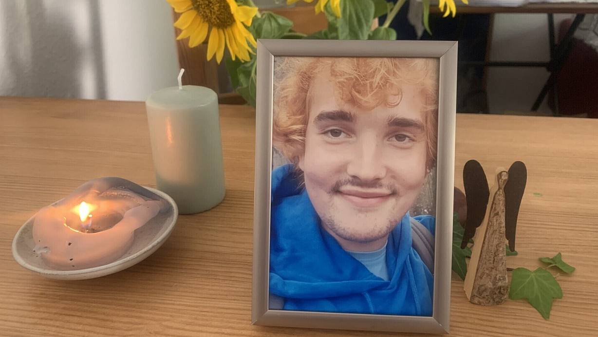 Ein letztes Foto von Max (Name von der Redaktion geändert) steht zusammen mit einer Kerze, einem Schutzengel und leuchtend gelben Sonnenblumen auf dem Esstisch der Familie. | © Ivonne Michel