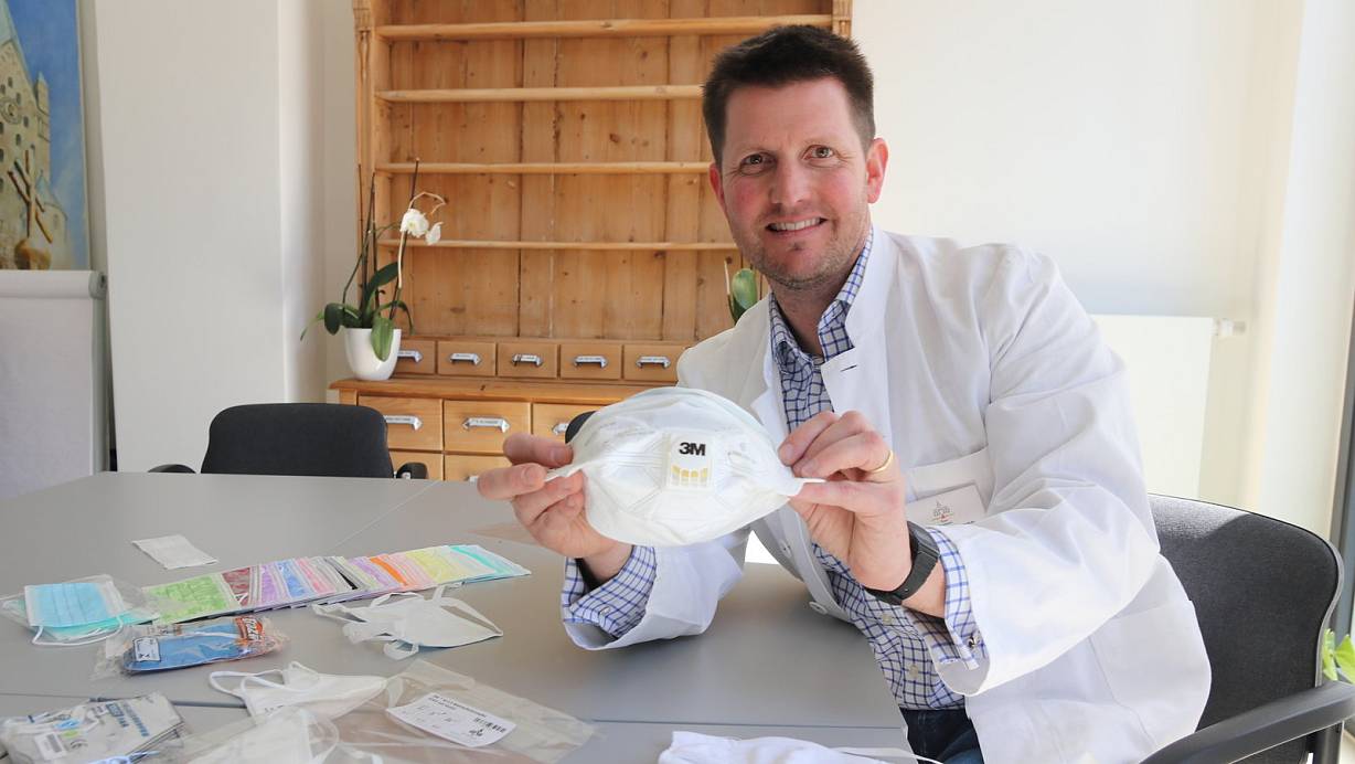 Philipp Hoffmann, Kreisvertrauensapotheker im Kreis Paderborn, zeigt unterschiedliche Typen von Mundschutzmasken. Er hält eine FFP-2 Maske mit Ventil, die die eingeatmete Luft filtert. | © Mareike Gröneweg