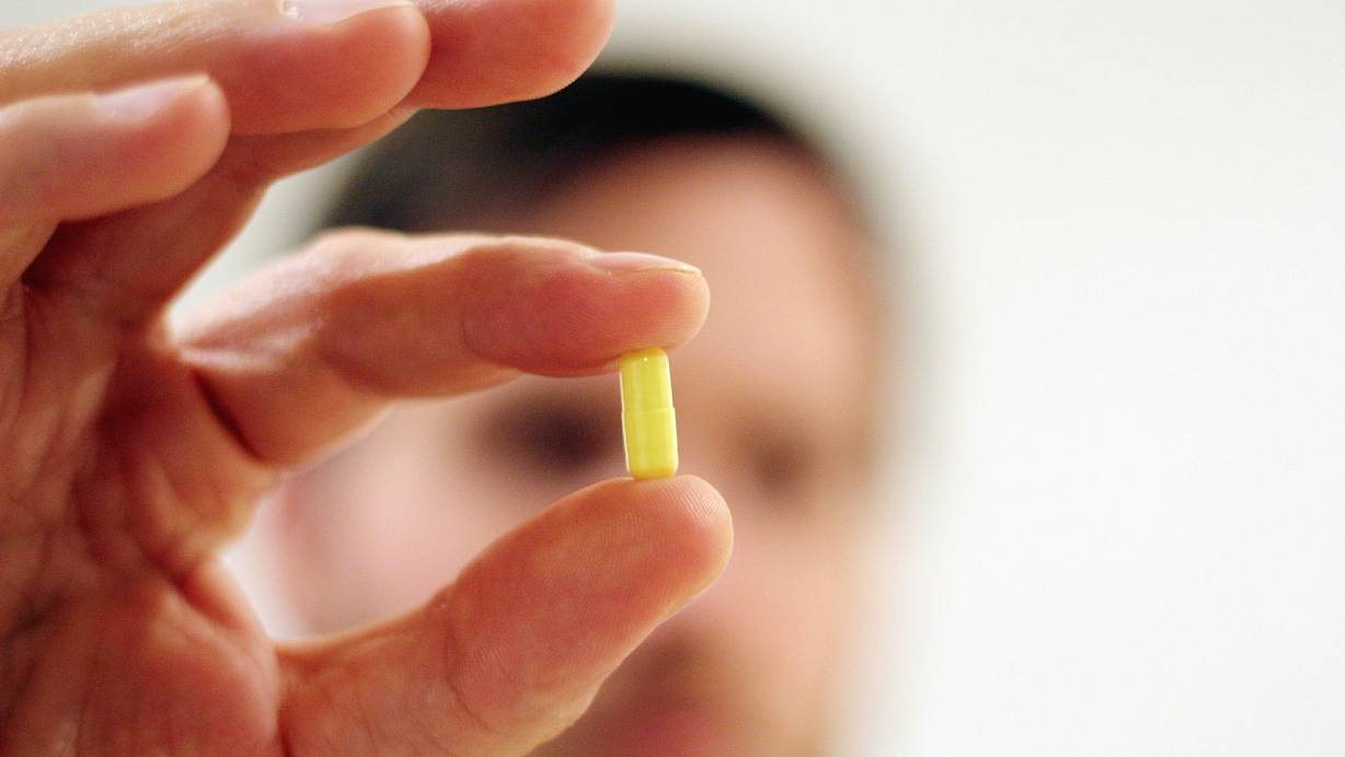 Ein Mann hält eine Medikamenten-Kapsel in der Hand. Viele Antibiotika enthalten Fluorchinolone (Symbolfoto)<strong>.</strong> | © picture alliance/dpa