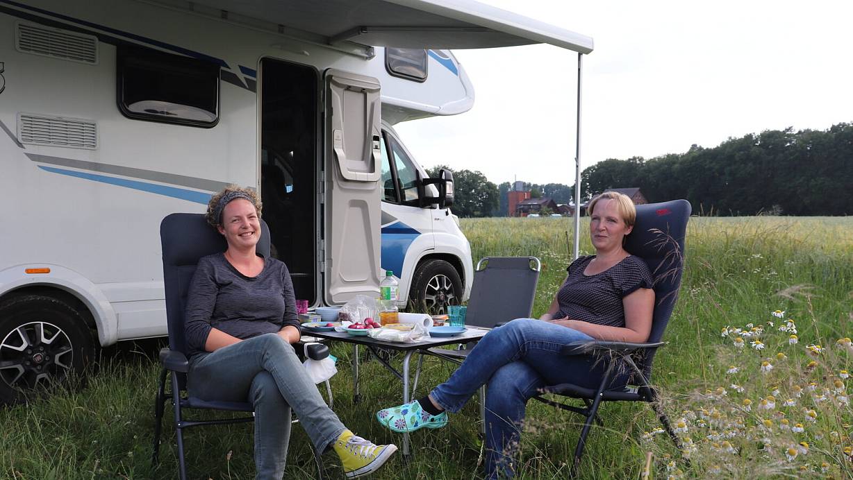 Sonja Lange (l.) und Sabine Rose verbringen am Feldrand eine Nacht in ihrem Wohnmobil "Lacki Elmo". Den Platz finden sie "mega, ein echtes Träumchen". | © Marion Pokorra-Brockschmidt
