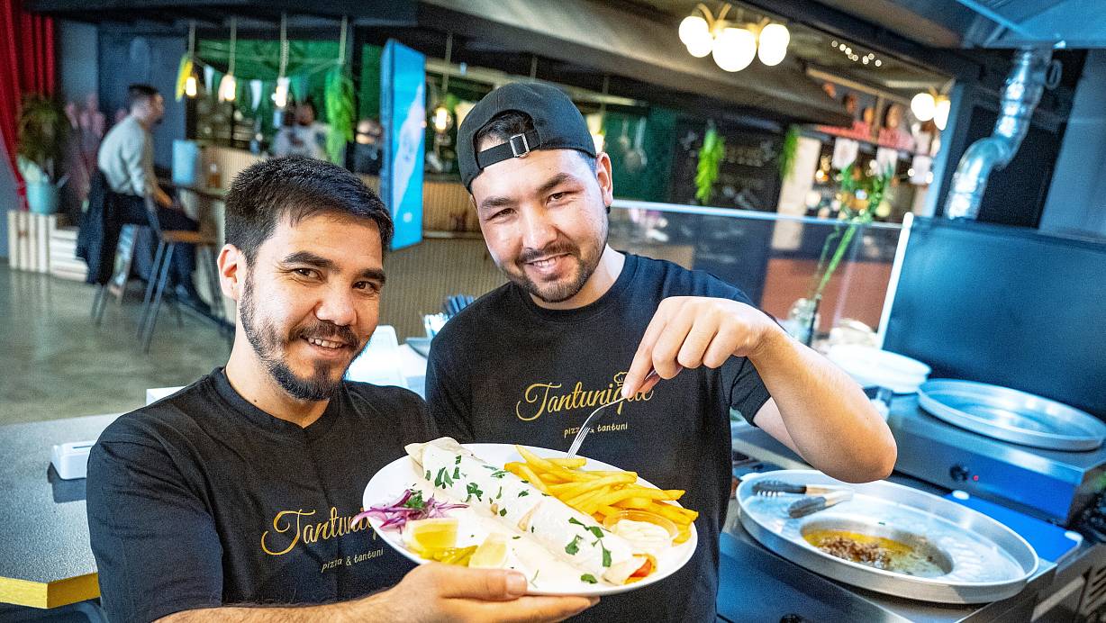 Reza Nazary (l.) und Abuzar Ghorbani präsentieren einen Tantuni mit Pommes. | © Barbara Franke