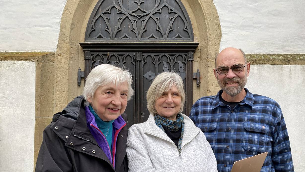 Ahnenforschung mit Laptop und Internet. Sonja Ruthe (Mitte) aus Victoria in Kanada fand ihre Vorfahren in unserer Region. Mit ihrem Mann Johann Cunningham und Inge Berghoff vom Heimatverein Oerlinghausen, die sie bei ihren Recherchen unterstützte, steht sie vor der sogenannten Hochzeitstür der Alexanderkirche. | © Foto: Horst Biere