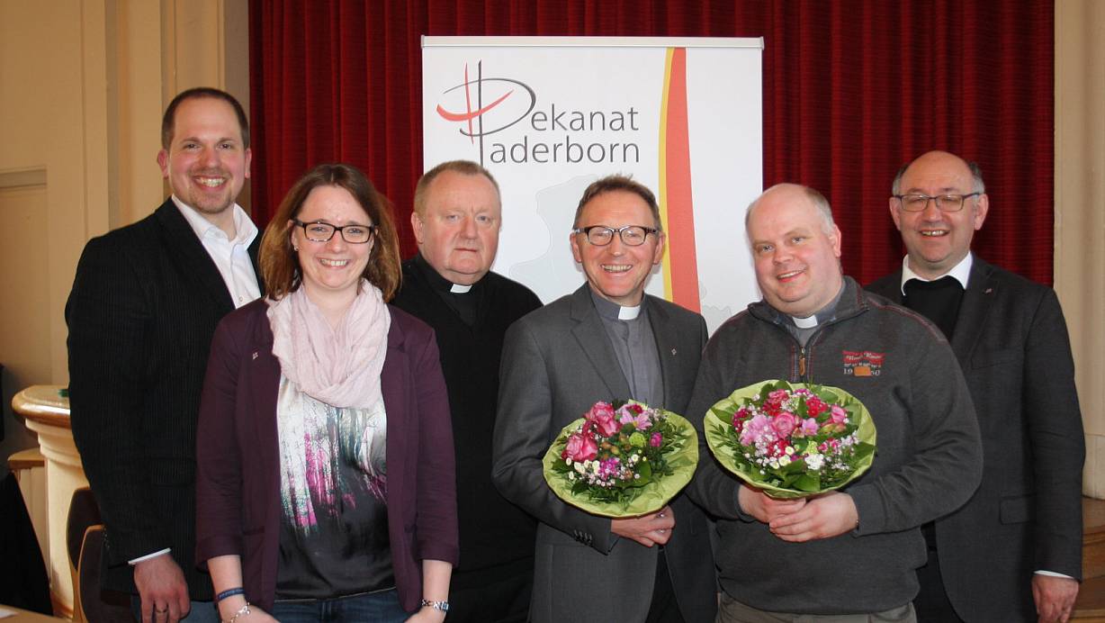 Gemeinsam für das Dekanat: Der im Amt bestätigte Dechant Benedikt Fischer und das neue Priesterratsmitglied Henner Pohlschmidt (Mitte, mit Blumensträußen) mit (v.l.) Dekanatasreferent Rainer Fromme, Jugend- und Familienreferentin Theresa Bartz, sowie den stellvertretenden Dechanten Pfarrer Andreas Schottek und Pfarrer Georg Kersting. | © Birger Berbüsse