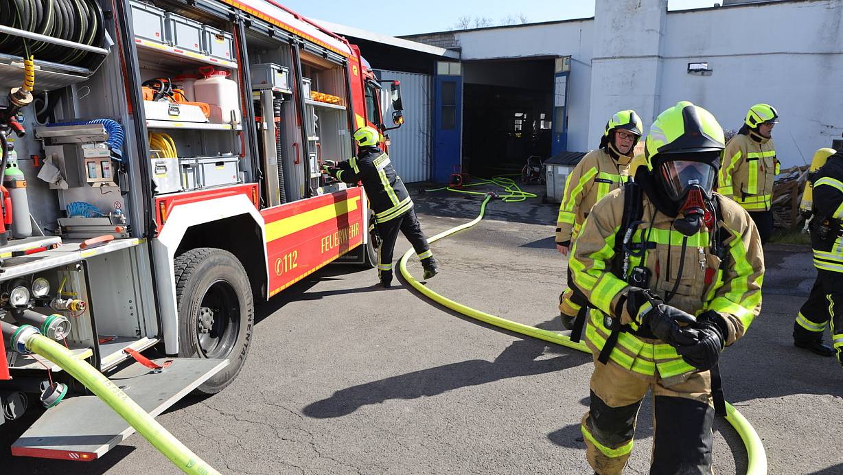 Unter schwerem Atemschutz kehren diese Feuerwehrleute aus der verqualmten Produktionshalle zurück. | © Jörg Stuke
