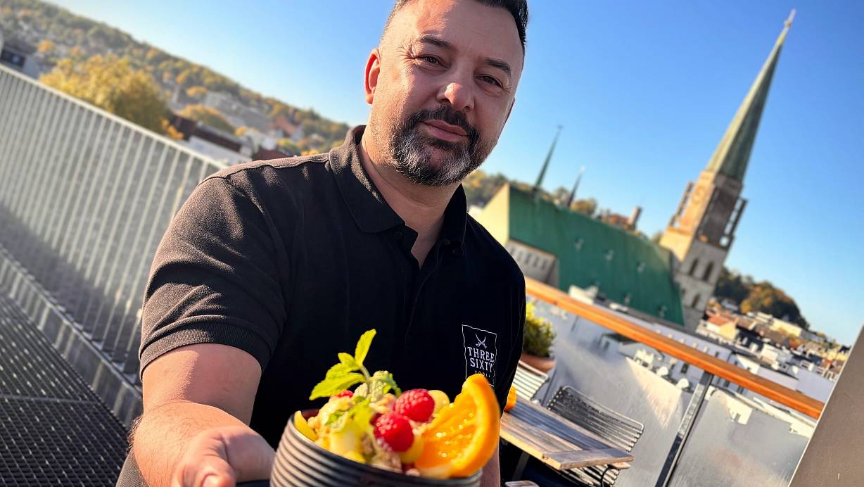 Atakan Sandal präsentiert auf der Dachterrasse einen Frucht-Bowl. Die Freiluftfläche ist bei den Gästen beliebt und bei Sonnenschein stets gut bevölkert. | © Eike J. Horstmann