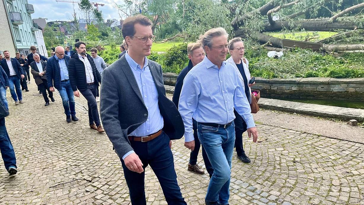 Im Paderquellgebiet ließ sich Ministerpräsident Hendrik Wüst (l.) von Paderborns Bürgermeister Michael Dreier erläutern, wie sich der Tornado am Freitagabend seinen Weg gebahnt hat. Im Hintergrund sind abgesägte und umgestürzte Bäume zu sehen. | © Jens Reddeker