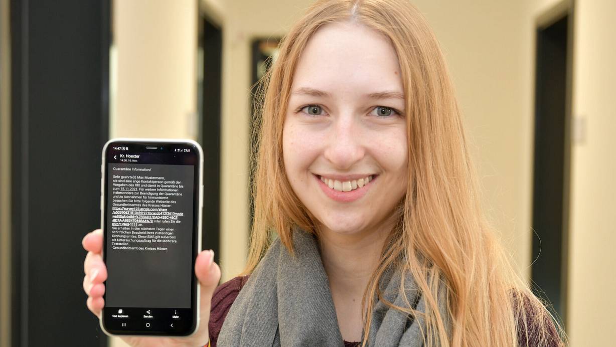 Pia Timpert zeigt auf ihrem Smartphone, wie die SMS aussieht, mit der die Kontaktperson informiert wird. | © Kreis Höxter