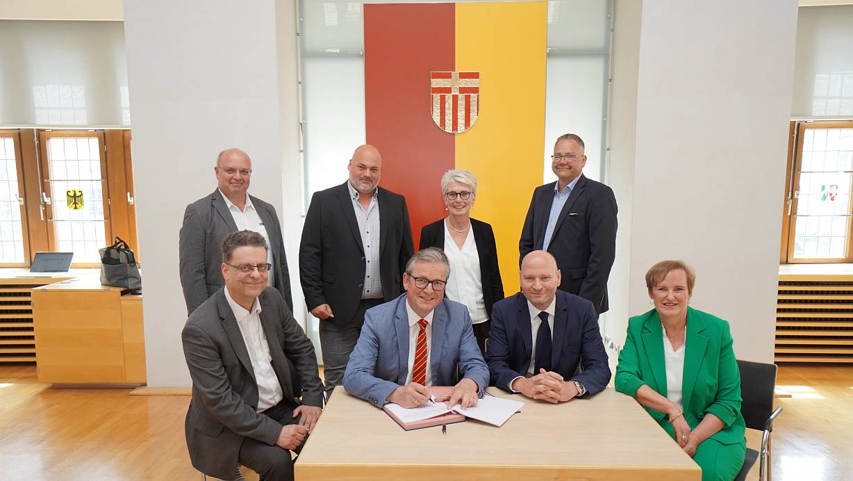 Der Kaufvertrag ist im Beisein von (vorne, v. l.) Kämmerer Markus Tempelmann, Bürgermeister Michael Dreier, Jochen Altrogge (Leiter Verkauf Nordrhein-Westfalen bei der Bima) und Silvia Auffahrt (Abteilungsleiterin Verkauf Nordrhein-Westfalen bei der Bima) sowie (hinten, v. l.) Christian Kleinschnittger, Boris Blume (beide städtisches Amt für Liegenschaften und Wohnungswesen), Claudia Warnecke (Technische Beigeordnete) und Lars-Christian Lange (Konversionsbeauftragter) unterschrieben worden. | © Stadt Paderborn/Lea Giesen