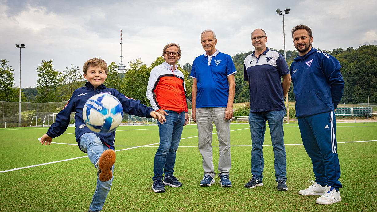 Frisches Grün statt staubiger Asche: Luis (9) aus der D-Jugend, Dirk Meyer, Jürgen Blume und die Trainer Torsten Esser und Luan Medzini (v.l.) vom TuS Hoberge-Uerentrup freuen sich, dass der Kunstrasentraum jetzt Wirklichkeit geworden ist. | © Mike-Dennis Müller / www.mdm.photo