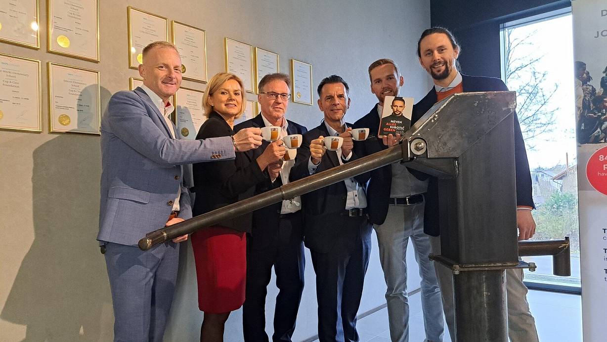 Die Vorstandsmitglieder der Cup & Cino Foundation (v. l.) Sean Adams, Sabine Epping, Ludger Kleine, Frank Epping und Dominik Düsterhus präsentieren gemeinsam mit Neven Subotic das Modell einer Brunnenpumpe, das die Räumlichkeiten der Hövelhofer Firma ziert. | © Matthias Reiprich